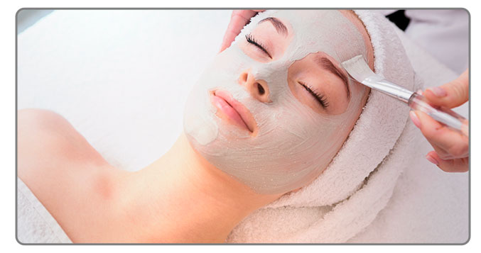Image of a Woman getting a face mask at a spa